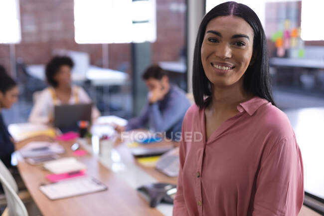 Портрет деловой женщины смешанной расы в конференц-зале, смотрящей на улыбающуюся камеру. независимый бизнес креативного дизайна. — стоковое фото