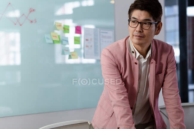 Portrait of stylish asian businessman looking right side. business person at work in modern office. — Stock Photo