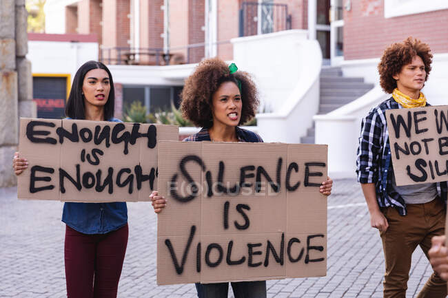 Three diverse male and female protesters on march walking holding homemade protest signs. equal rights and justice demonstration march. — Stock Photo
