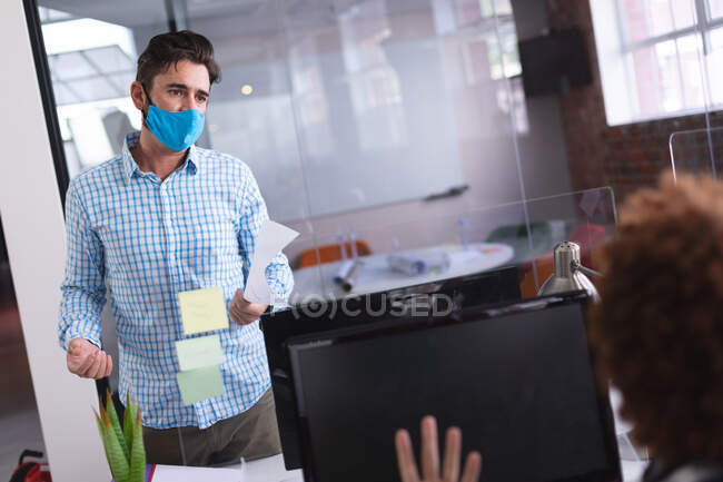 Homem de negócios caucasiano usando máscara em discussão no trabalho. negócio de design criativo independente durante a pandemia do coronavírus covid 19. — Fotografia de Stock