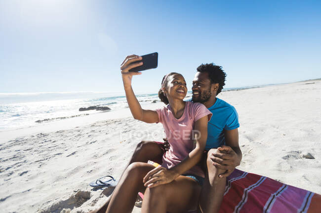 Счастливая африканская американская пара на пляже у моря делает селфи. здоровый отдых на открытом воздухе у моря. — Stock Photo