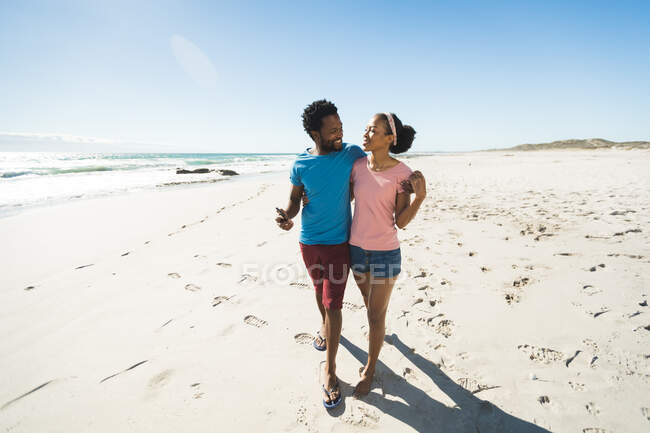 Счастливая африканская американская пара на пляже у моря обнимает. здоровый отдых на открытом воздухе у моря. — стоковое фото