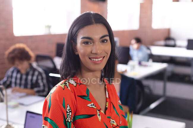 Porträt einer Geschäftsfrau mit gemischter Rasse im Büro, die in die Kamera lächelt. unabhängiges kreatives Designgeschäft. — Stockfoto