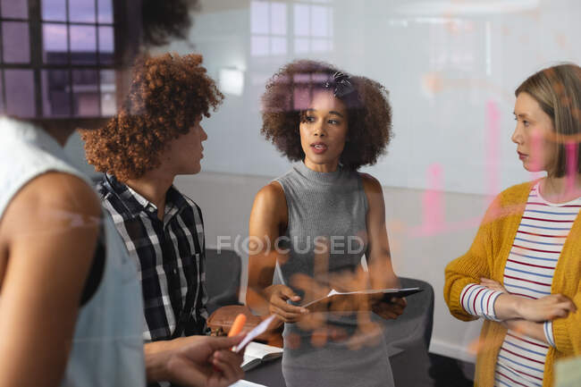 Diverse group of creative colleagues brainstorming in meeting room holding documents taking notes. independent creative design business. — Stock Photo