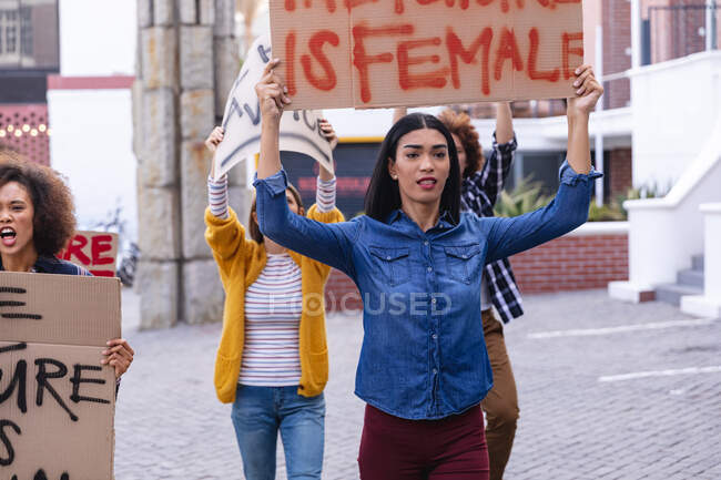 Manifestante de race mixte en marche tenant une pancarte de protestation maison au-dessus de sa tête. manifestation pour l'égalité des droits et la justice. — Photo de stock