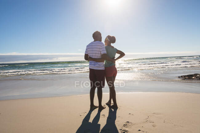 Happy african american couple on the beach embracing. healthy outdoor leisure time by the sea. — Stock Photo