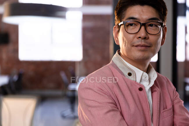 Portrait of stylish asian businessman looking to right side. business person at work in modern office. — Stock Photo