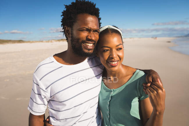 Щаслива афро-американська пара на пляжі обіймає. Здоровий вільний час на відкритому повітрі біля моря. — стокове фото