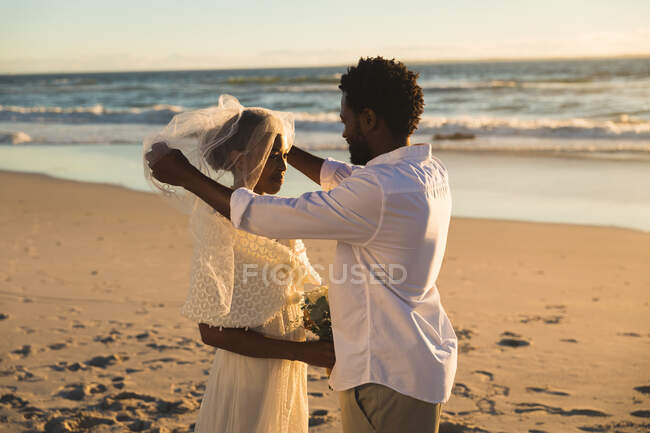 Pareja afroamericana enamorada de casarse en la playa. amor, romance y playa boda vacaciones de verano. - foto de stock
