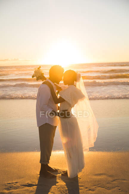 Coppia afroamericana innamorata di sposarsi, abbracciarsi sulla spiaggia durante il tramonto. amore, romanticismo e matrimonio vacanza al mare vacanza estiva. — Foto stock