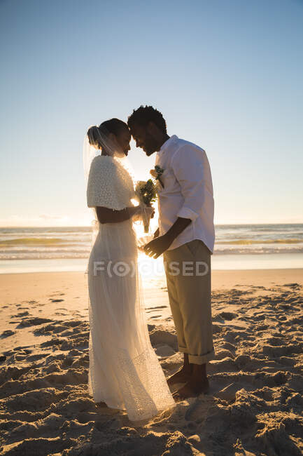 Couple afro-américain amoureux se marier sur la plage touchant les fronts. amour, romance et pause plage vacances d'été. — Photo de stock