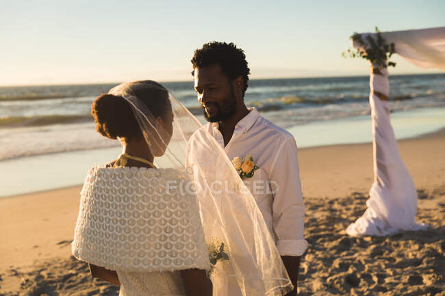 Coppia afroamericana innamorata di sposarsi sulla spiaggia guardando l'un l'altro. amore, romanticismo e matrimonio in spiaggia vacanze estive. — Foto stock