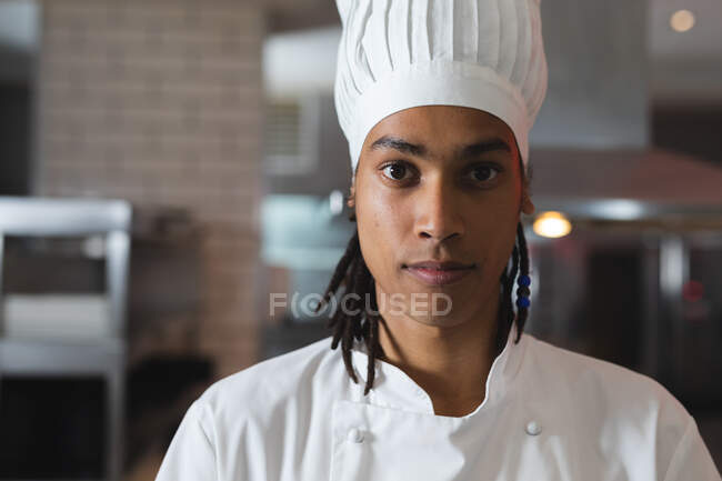 Porträt eines professionellen Koch mit gemischter Rasse mit Kochmütze. Koch bei der Arbeit in einer modernen Restaurantküche. — Stockfoto