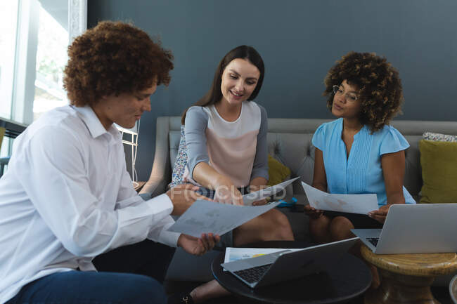 Diverse male and female of business colleagues sitting on sofa working and discussing. casual meeting in business lounge. — Stock Photo