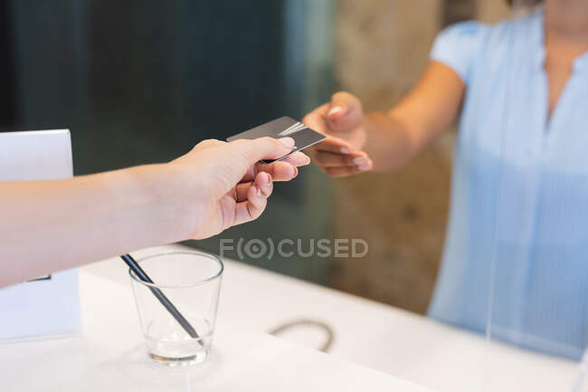Businesswomen wearing handing room key card to receptionist in hotel. business travel hotel during coronavirus covid 19 pandemic. — Stock Photo
