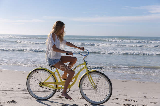 Kaukasische Frau mit Fahrrad am Strand. gesunde Freizeit im Freien am Meer. — Stockfoto