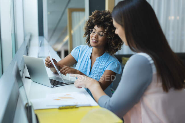Diverse female business colleagues sitting at window having a meeting. casual meeting in business lounge. — Stock Photo