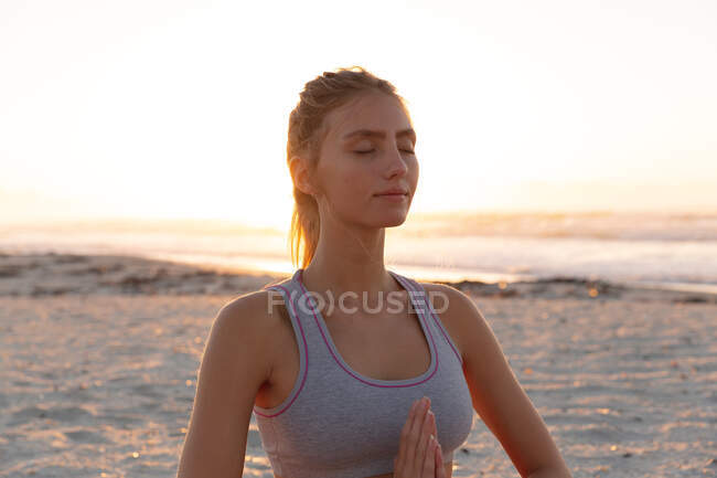 Caucasian woman meditating and practicing yoga at the beach. fitness yoga and healthy lifestyle concept — Stock Photo