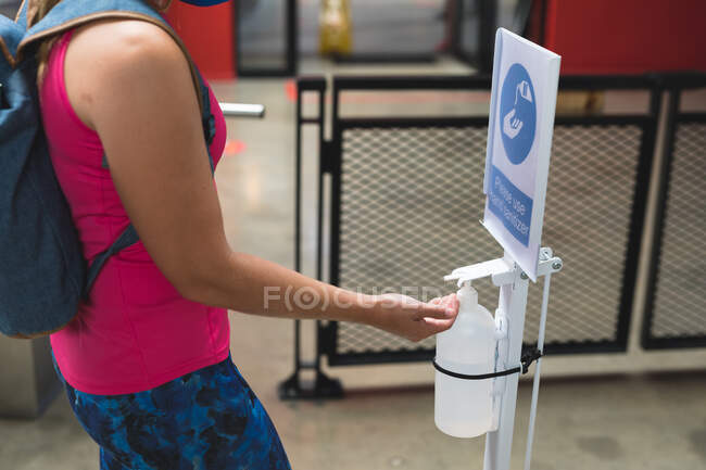 Frauen mit Masken desinfizieren im Fitnessstudio die Hände. Fitness und Freizeit im Fitnessstudio während der Coronavirus-Pandemie 19. — Stockfoto