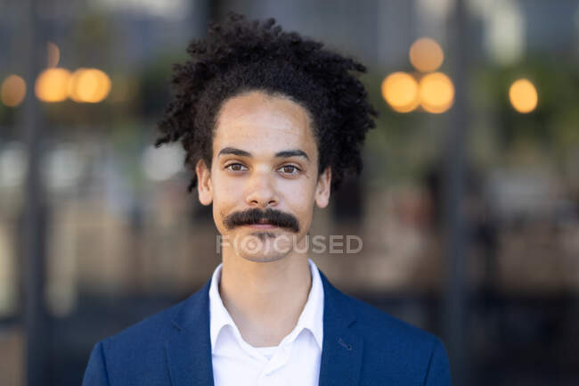 Portrait d'un homme de race mixte avec une moustache regardant vers la caméra. petite entreprise indépendante dans une ville. — Photo de stock