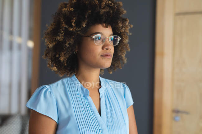 Portrait of mixed race woman wearing glasses standing in hotel lobby. hotel and travel business. — Stock Photo
