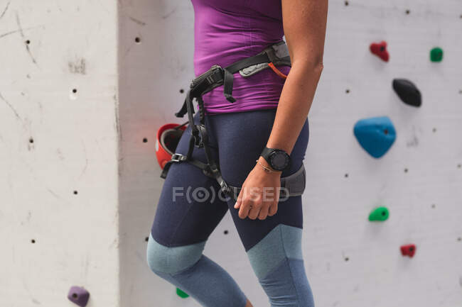 Midsection of woman preparing for climb at indoor climbing wall. fitness and leisure time at gym. — Stock Photo
