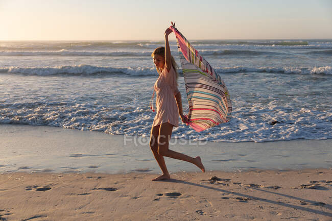 Mulher branca bonita segurando cachecol andando e desfrutando na praia. verão praia férias conceito. — Fotografia de Stock