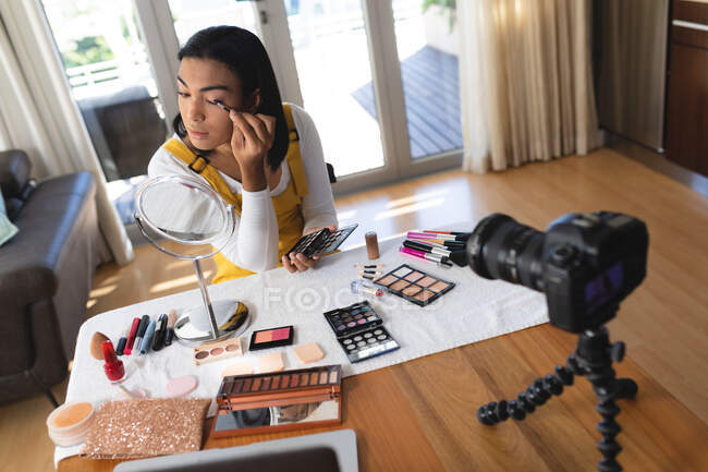 Mulher transexual mista feliz fazendo vlog usando laptop e câmera colocando maquiagem. ficar em casa em isolamento durante o confinamento de quarentena. — Fotografia de Stock