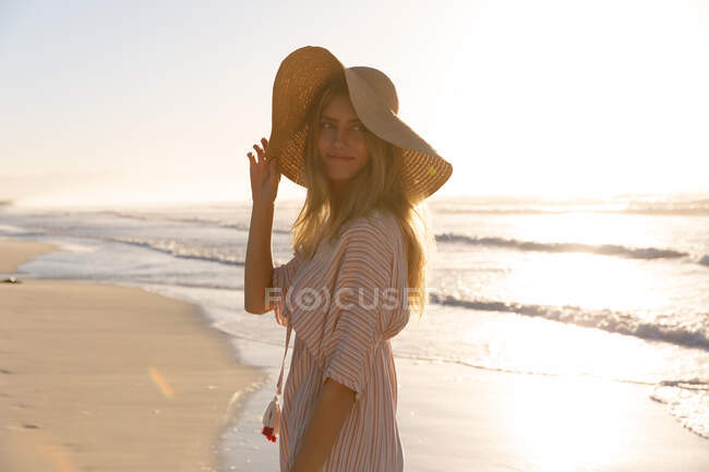 Жінка в бічному покритті і капелюсі розважаються на пляжі. Здоровий вільний час на відкритому повітрі біля моря. — стокове фото