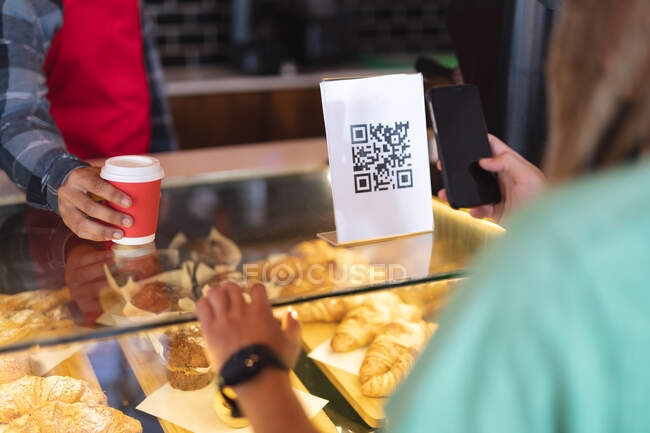 Mid section of two male taking picture of qr code and passing coffee. independent small business in a city. — Stock Photo
