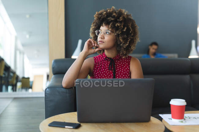 Retrato de mulher de negócios mista sentada no sofá com laptop. reunião informal na sala de negócios. — Fotografia de Stock