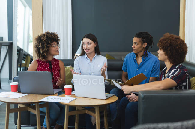 Diversos hombres y mujeres de colegas de negocios sentados en el sofá trabajando y discutiendo. reunión informal en el salón de negocios. - foto de stock