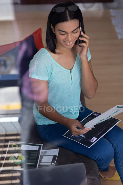 Mulher transgênero de raça mista trabalhando em casa falando no smartphone. ficar em casa em isolamento durante o confinamento de quarentena. — Fotografia de Stock
