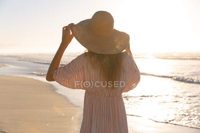Caucasian woman wearing beach cover up and hat having fun at the beach. healthy outdoor leisure time by the sea. — Foto stock