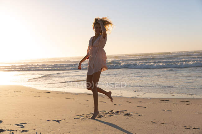Caucasian woman wearing bikini and sweater having fun at the beach. healthy outdoor leisure time by the sea. — Stock Photo