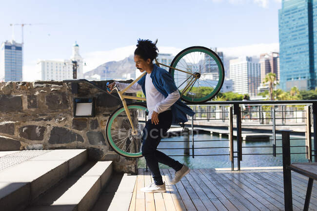 Homem de raça mista com bigode transportando bicicleta na rua. estilo de vida urbano verde, fora e sobre na cidade. — Fotografia de Stock