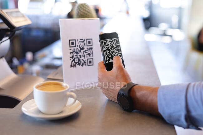 Uomo utilizzando smartphone e la lettura di codice QR in caffè. caffè indipendente, piccola impresa di successo. — Foto stock