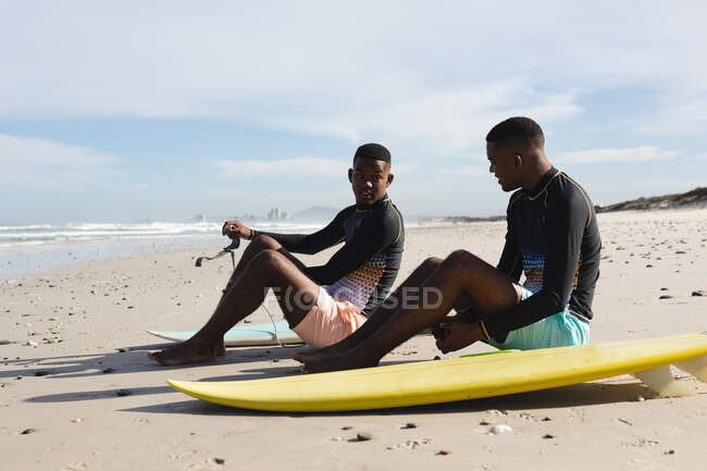 Африканські американські брати з серфінгами сидять на пляжі. Літні канікули та концепція дозвілля.. — стокове фото
