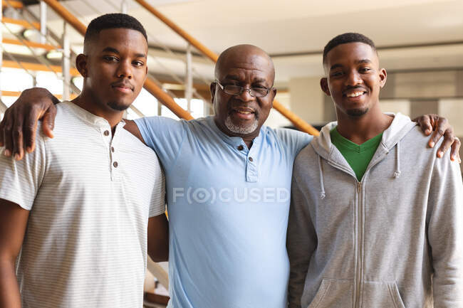 Porträt eines afrikanisch-amerikanischen Seniors und seiner beiden Söhne, die zu Hause lächeln. Vaterschaft und Familienkonzept — Stockfoto