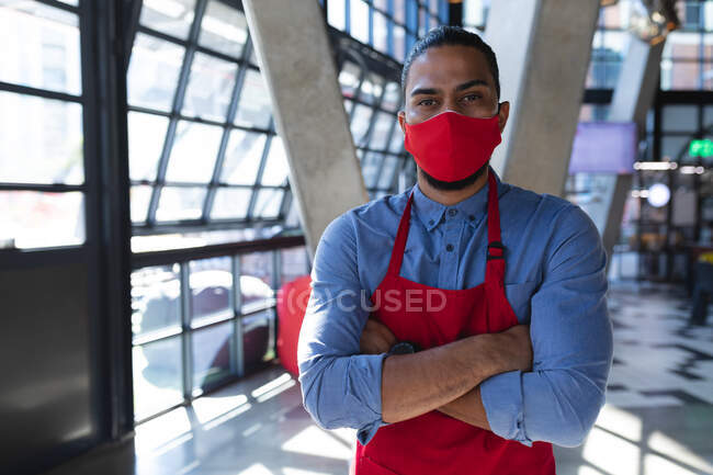 Retrato de barista mestiço usando máscara facial no café. café independente, negócios durante coronavírus covid 19 pandemia. — Fotografia de Stock