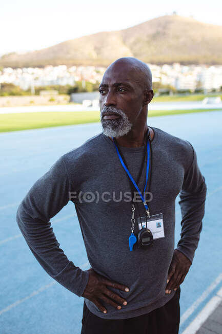 African american male coach with hands on hips standing in the stadium. paralympic sport concept — Stock Photo