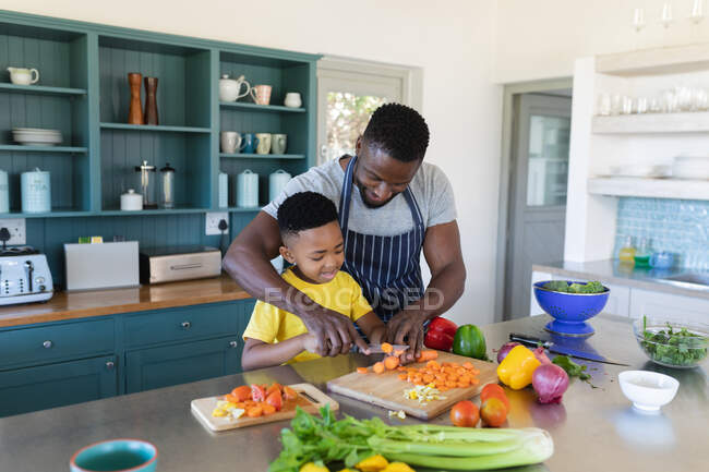 Африканський американський батько і син на кухні, готують разом. вдома в ізоляції під час карантину.. — стокове фото