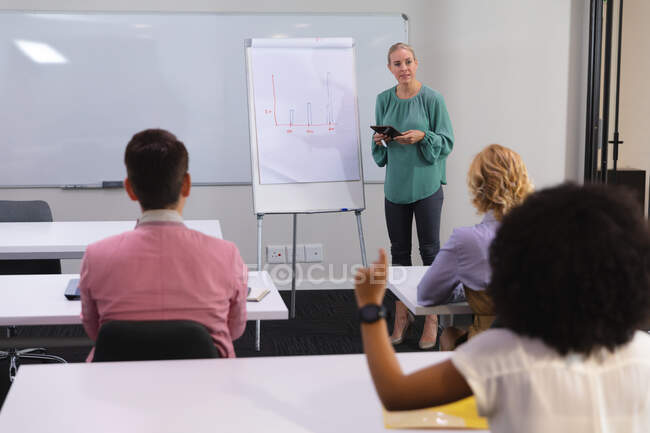 Donna caucasica che fa una presentazione ai suoi colleghi di ufficio nella sala riunioni dell'ufficio. business, professionalità, ufficio e concetto di lavoro di squadra — Foto stock