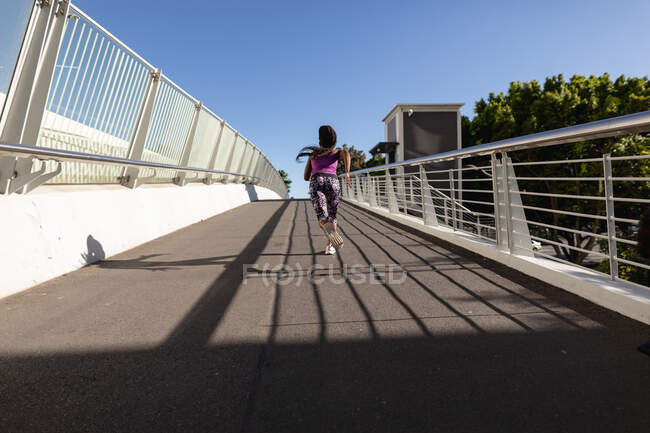Жирна афро-американська жінка, яка біжить пішки по мосту, займається вправами в місті. здоровий спосіб життя і зовнішній вигляд. — стокове фото