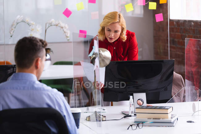 Kaukasische Frau liest ein Dokument, während sie neben ihrem Schreibtisch im Büro steht. Business, Professionalität und Bürokonzept — Stockfoto