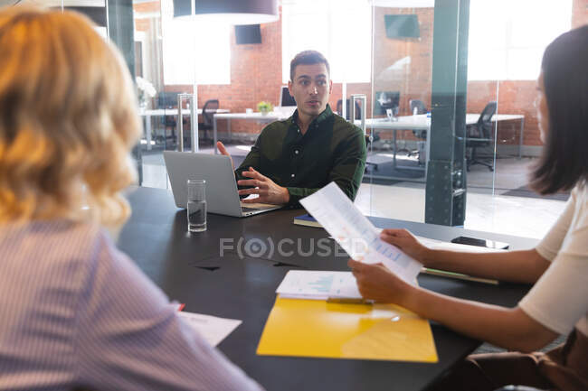 Team of diverse male and female office colleagues discussing together in meeting room at office. business, professionalism, office and teamwork concept — Stock Photo