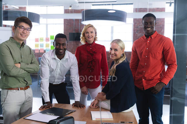 Portrait of team of diverse male and female office colleagues smiling together at office. business, professionalism, office and teamwork concept — Stock Photo