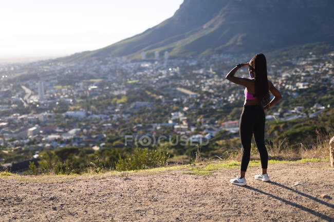 Fit african american woman admiring view during exercise in countryside. healthy active lifestyle and outdoor fitness during coronavirus covid 19 pandemic. — Stock Photo