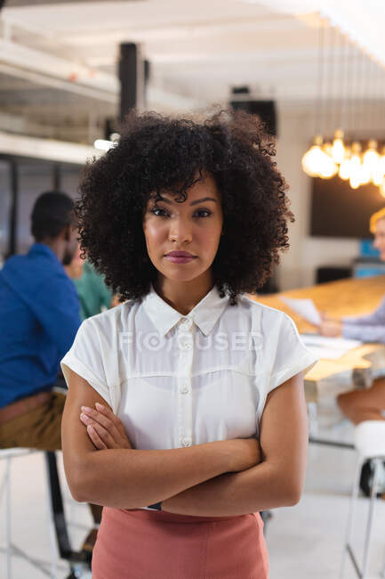 Портрет афро-американської жінки зі схрещеними руками стоїть у сучасному офісі. бізнес, професіоналізм і офісна концепція — стокове фото
