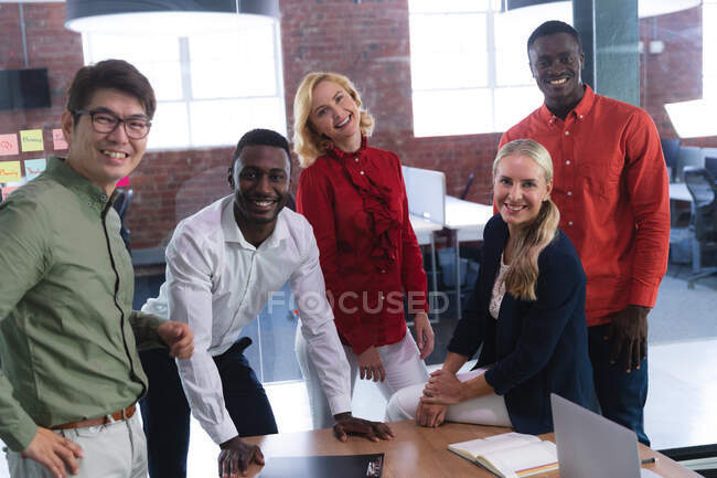 Retrato del equipo de diversos colegas de oficina masculinos y femeninos sonriendo juntos en la oficina. negocio, profesionalidad, concepto de oficina y trabajo en equipo - foto de stock